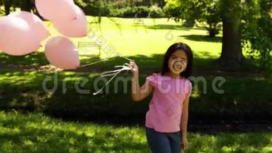 公园里的小女孩拿着气球来宣传乳腺癌